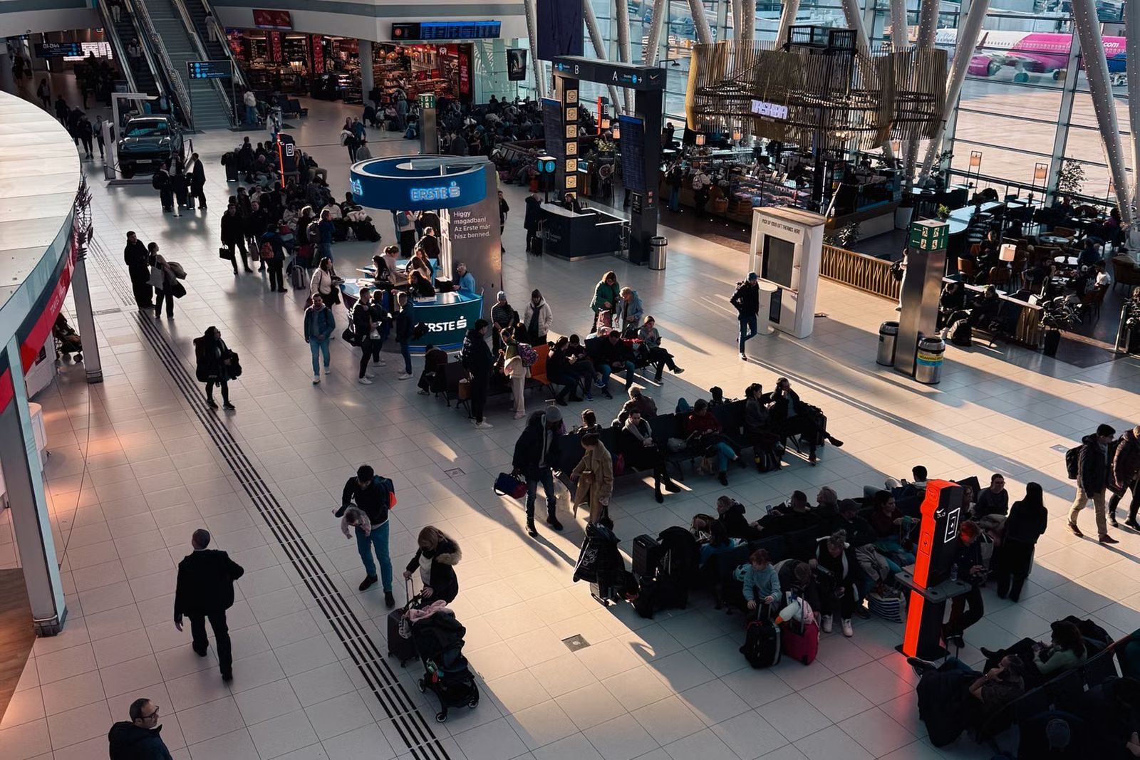 Travelers moving through a busy airport terminal